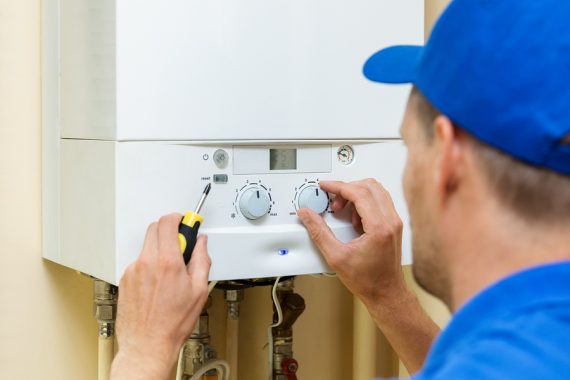 Worker setting up system for hot water cylinders